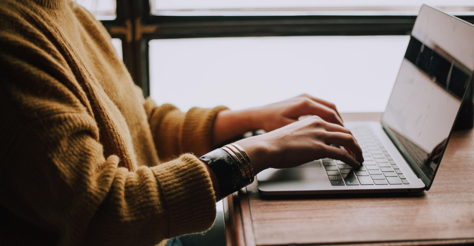 Person sitting at a desk typing on a keyboard