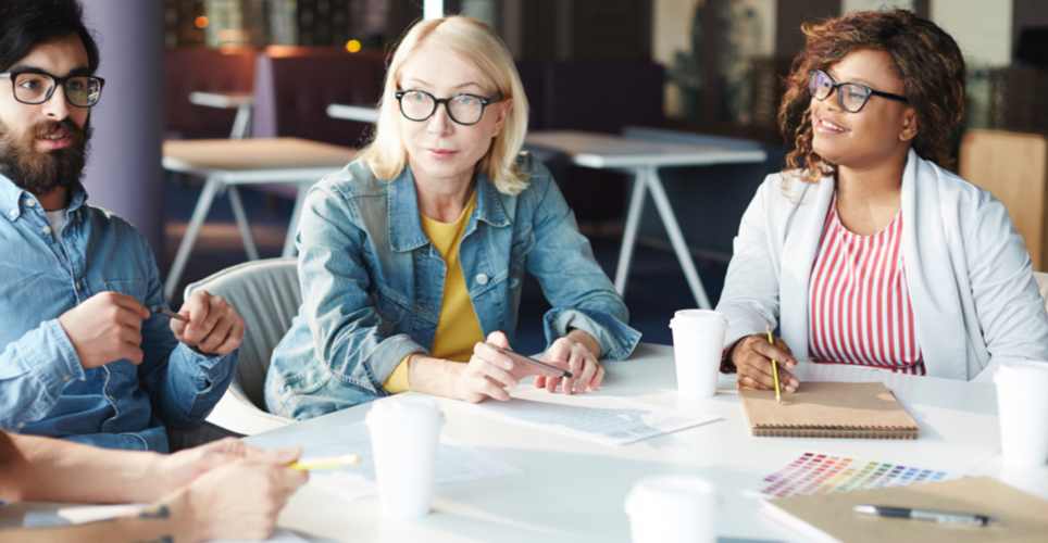 Three people sitting at a table learning. 