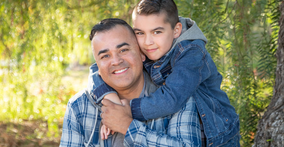 Close up of an adult dad of color and his young son