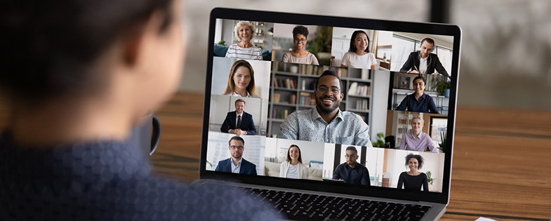 someone looking a laptop, attending a virtual meeting