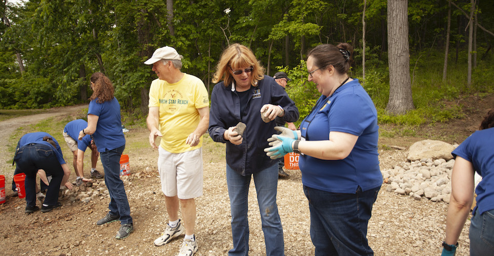 Voices Team members helping to move river rocks at the 2019 annual meeting.