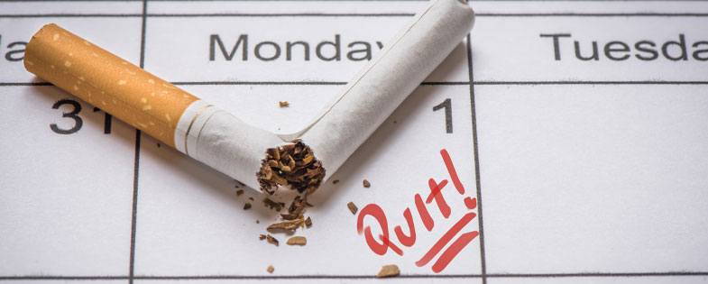 broken cigarette on a calendar with Quit written on it.