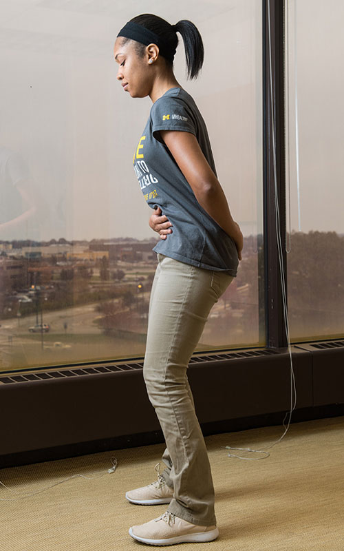 Young woman standing showing postural correction end movement