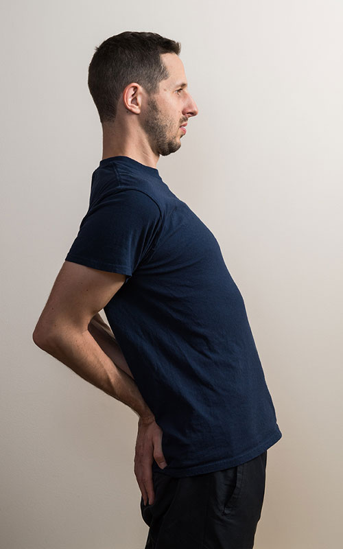 Young man standing showing standing arch extension end movement