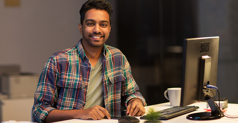 Man smiling while working at computer.