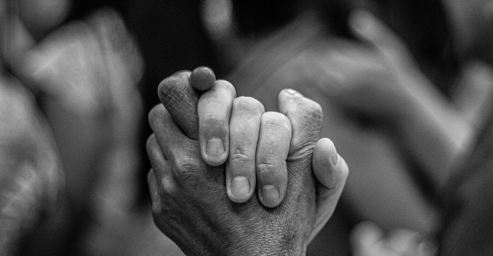 Close up of two hands clasped, suggesting support.  