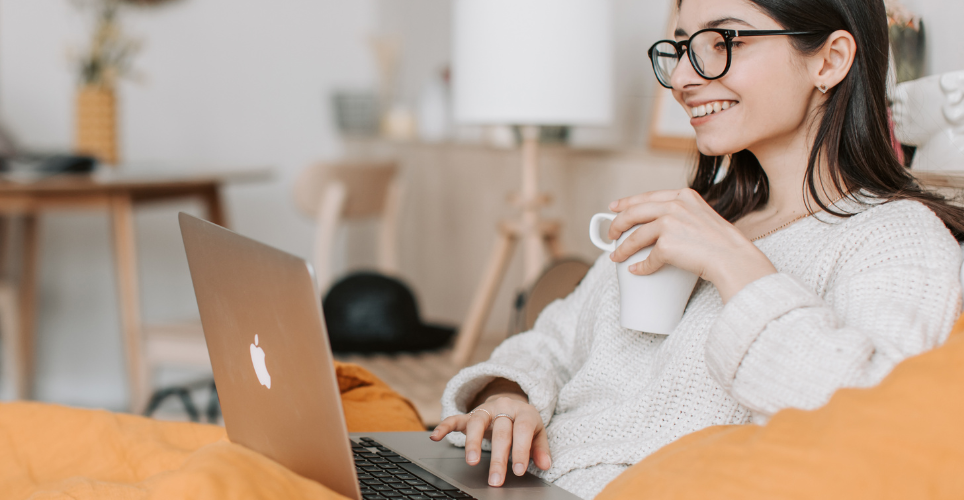 Woman wearing glasses, working on a laptop computer