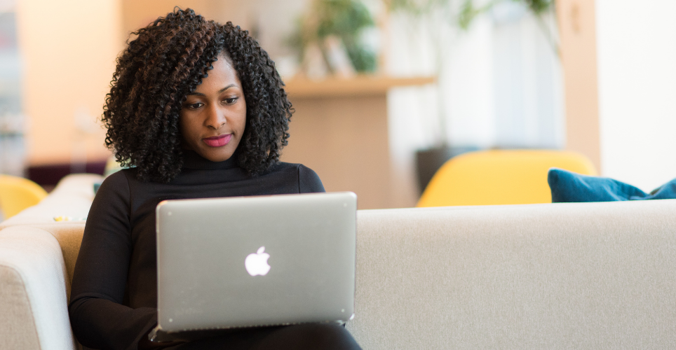 Woman sitting on couch using her laptop.