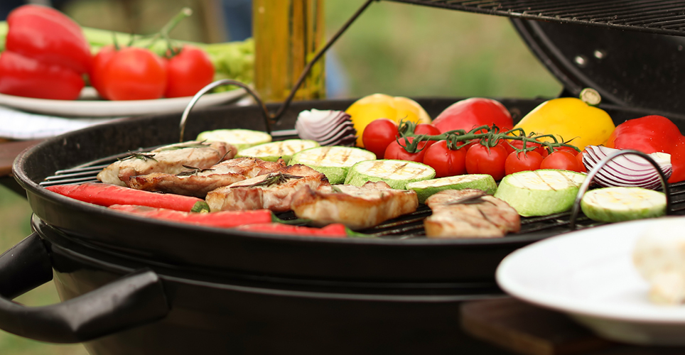 vegetables and meats being cooked on a grill