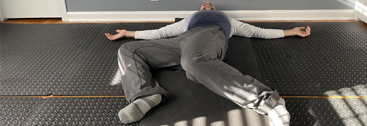 man laying on floor with knees bent to the side