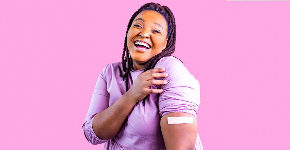 An African-American woman with a bandage on her arm from a shot.